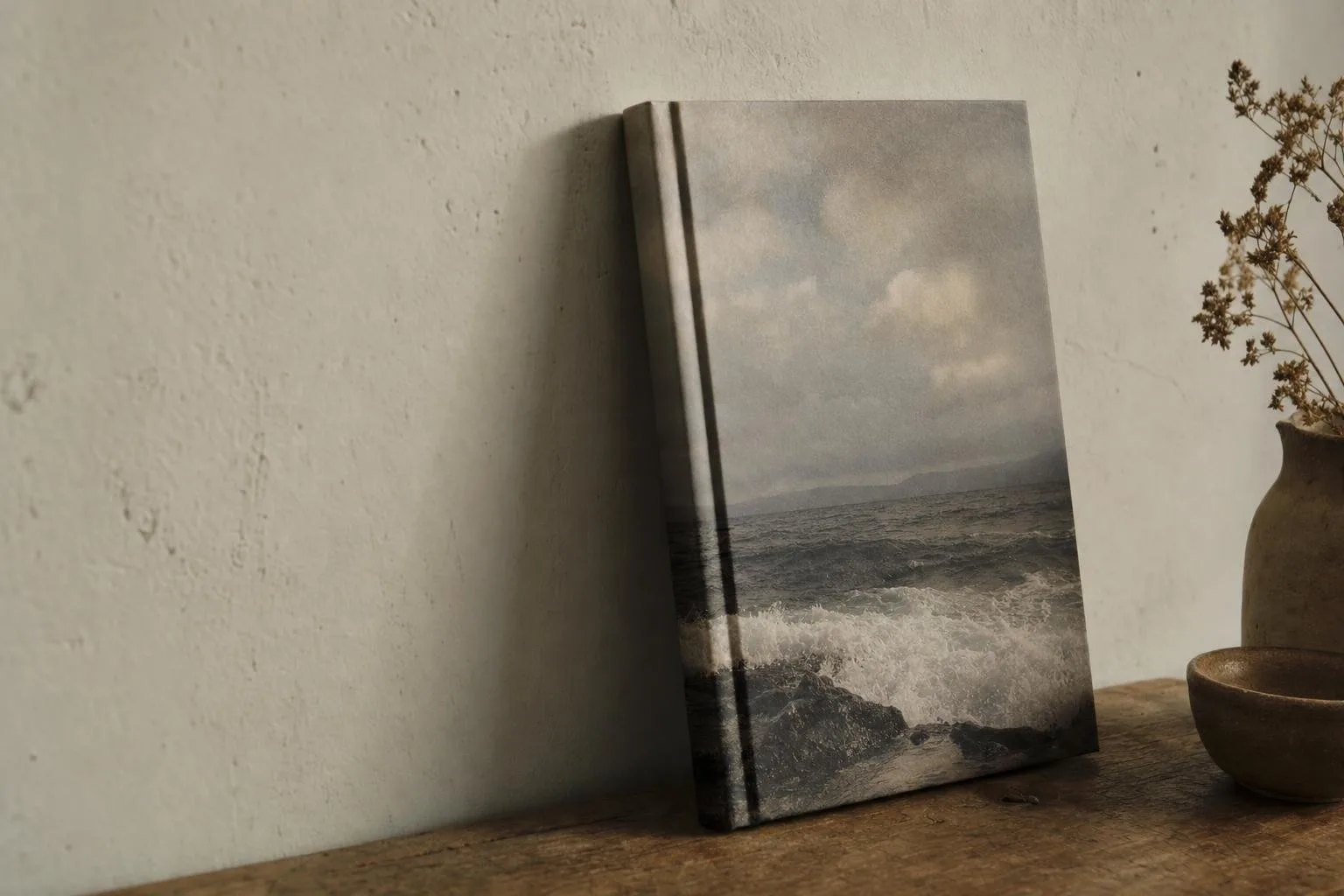 Hardcover of The Tide Between Us resting against a plain wall